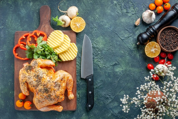 Vue de dessus du poulet cuit épicé avec des pommes de terre sur la surface sombre