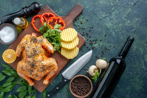 Vue de dessus du poulet cuit épicé avec des pommes de terre sur la surface sombre