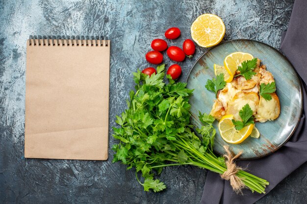 Vue De Dessus Du Poulet Avec Du Fromage Sur Le Plateau Bouquet De Persil Demi-citron Tomates Cerises Bloc-notes Sur Tableau Gris