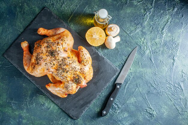 Vue de dessus du poulet épicé cuit avec de l'huile sur une surface sombre