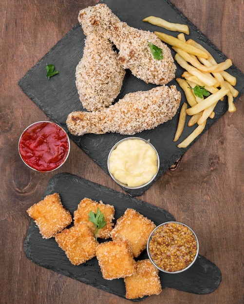 Vue de dessus du poulet frit avec différents types de sauce et frites