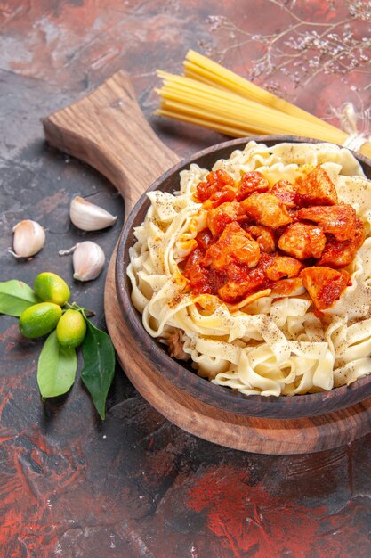 Vue de dessus du poulet avec un plat de pâtes de pâte sur le plat de surface sombre pâte de pâtes foncée