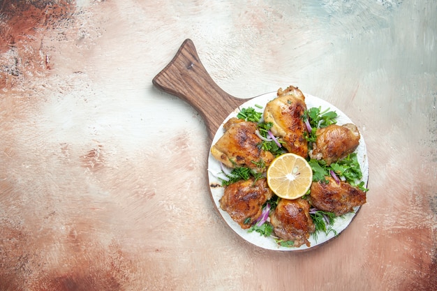 Vue de dessus du poulet un poulet appétissant avec de l'oignon aux herbes de citron sur la planche à découper