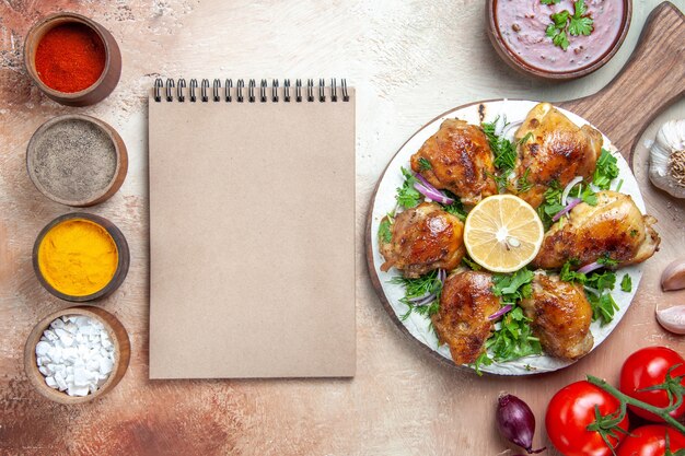 Vue de dessus du poulet sauce aux épices colorées poulet aux herbes oignon tomates cahier à la crème