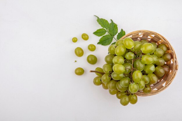 Vue de dessus du raisin blanc dans le panier et sur fond blanc avec espace copie