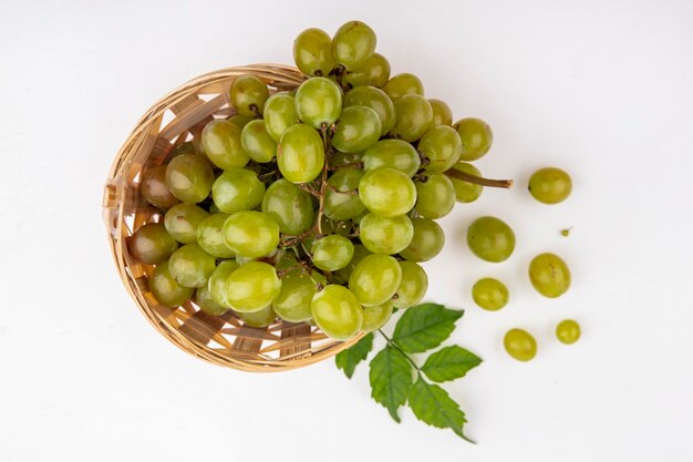 Vue de dessus du raisin blanc dans le panier et sur fond blanc