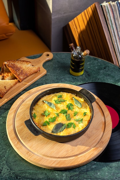 Une vue de dessus du repas aux œufs à l'intérieur de la casserole avec du pain sur la table couleur de l'oeuf repas