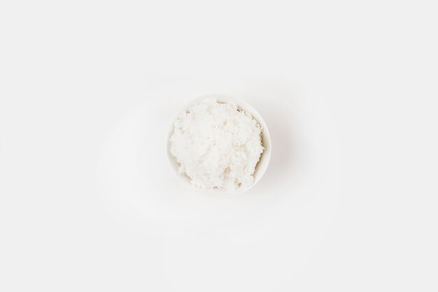 Une vue de dessus du riz bouilli cuit dans un bol sur fond blanc