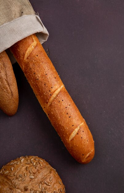 Vue de dessus du sac avec baguettes et épis ensemencés sur fond marron avec copie espace