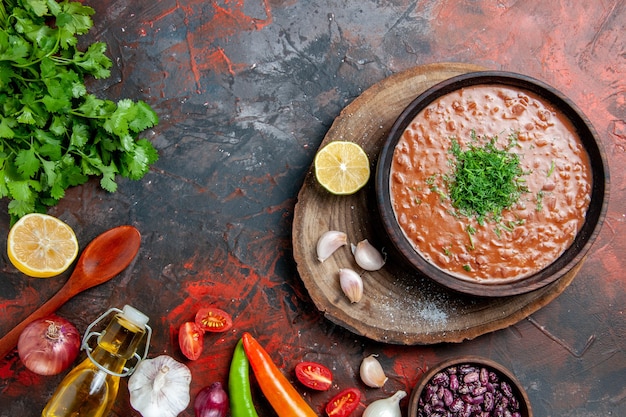 Vue de dessus du savon de tomate classique haricots cuillère ail bouteille d'huile ketchup au citron sur table de couleurs mixtes