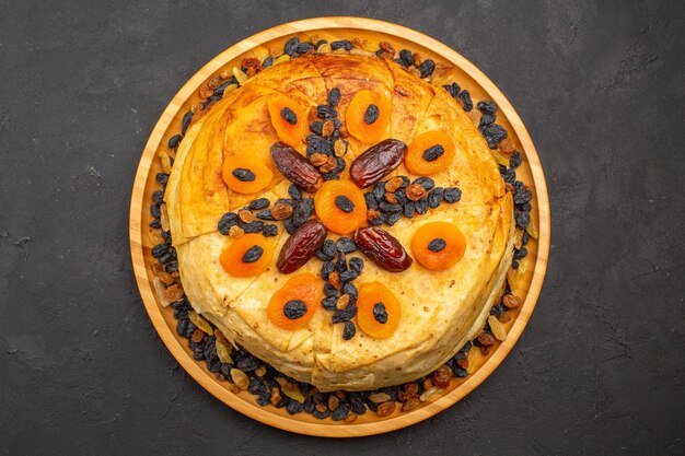 Vue De Dessus Du Savoureux Riz Cuit Shakh Plov à L'intérieur D'une Pâte Ronde Avec Des Raisins Secs Sur Une Surface Grise