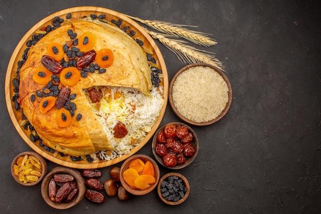 Vue de dessus du savoureux shakh plov avec des raisins secs et des abricots secs sur la surface sombre