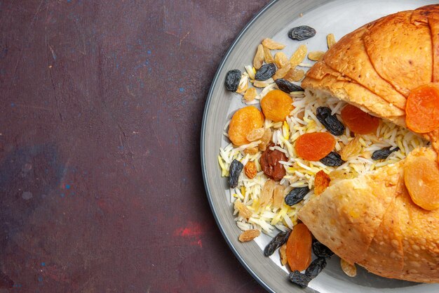 Vue de dessus du savoureux shakh plov avec des raisins secs sur la surface sombre