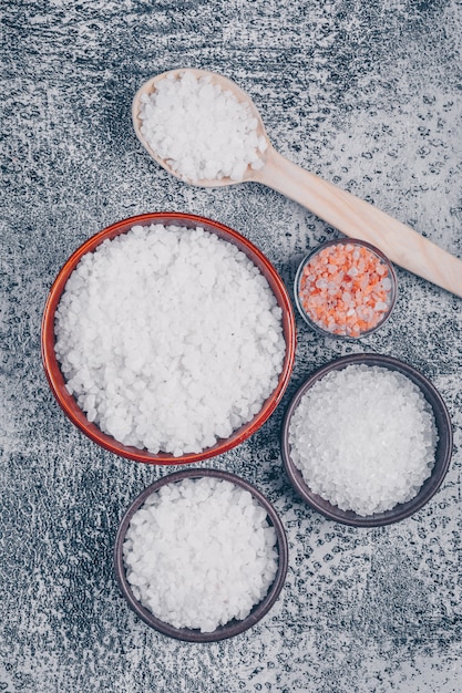Photo gratuite vue de dessus du sel en verre, bols et cuillère en bois avec sel de l'himalaya
