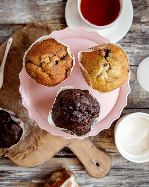 Vue de dessus du stand de gâteau rose avec trois muffins