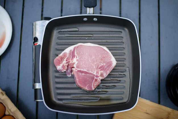 Vue de dessus du steak cru et des herbes sur une poêle à griller Cuisine repas barbecue Activité d'été et concept de vacances