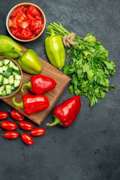 Vue de dessus du support de plaque avec des légumes sur fond sombre