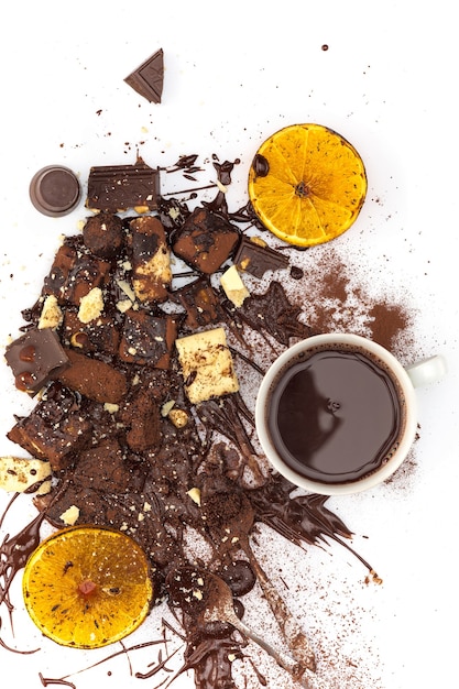 Photo gratuite la vue de dessus du tas de chocolat cassé et de chocolat chaud sur une table blanche au studio