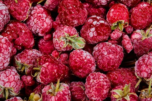 Vue de dessus du tas de framboises dans un panier en bois.