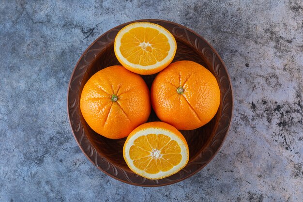 Vue de dessus du tas d'oranges fraîches en assiette.