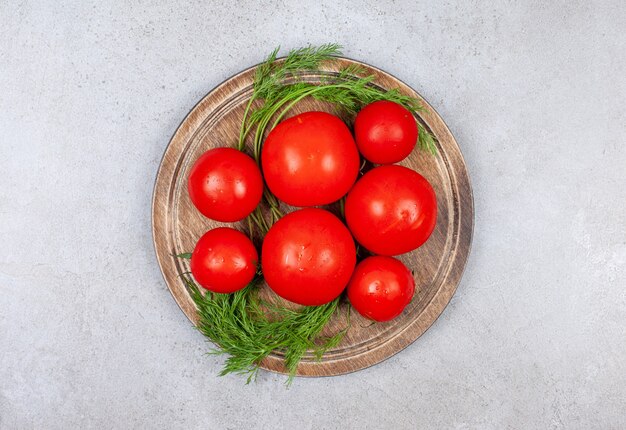 Vue de dessus du tas de tomates rouges sur planche de bois.