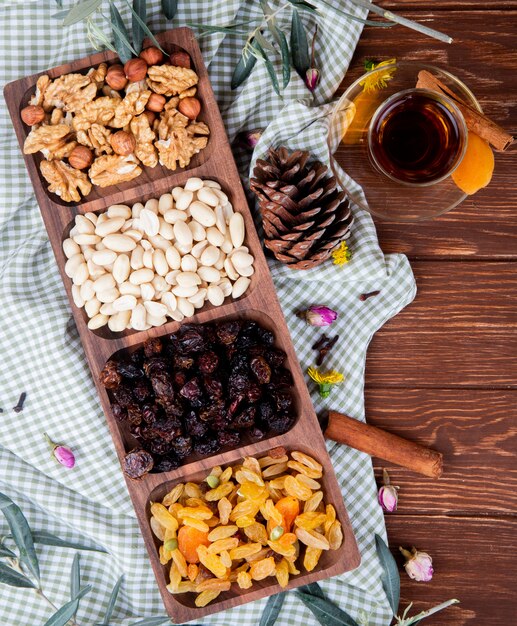 Vue de dessus du thé en verre armudu avec noix mélangées et fruits secs dans une boîte en bois sur bois