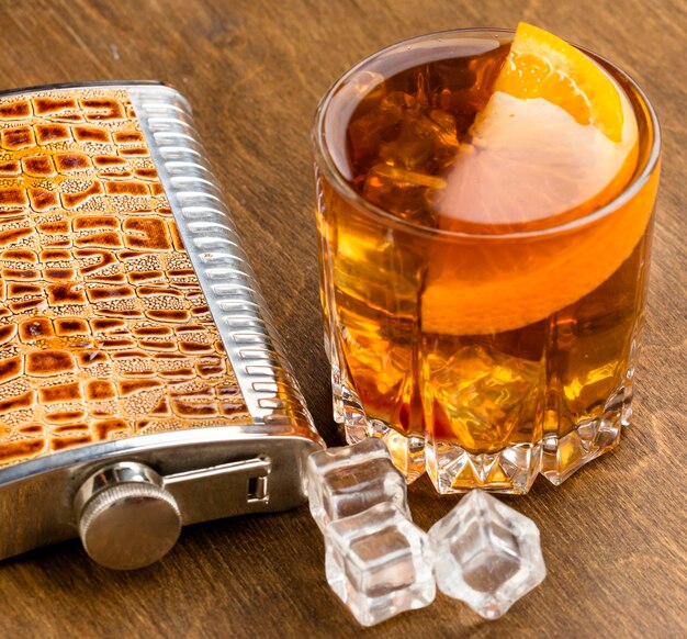 Vue de dessus du whisky sur les rochers avec orange et flacon