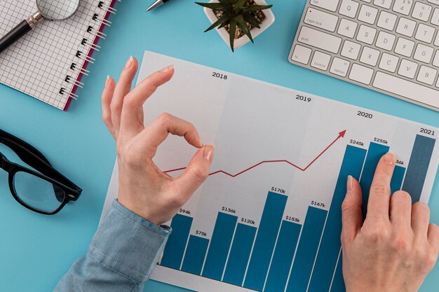 Vue de dessus des éléments commerciaux avec courbe de croissance et mains donnant un signe correct