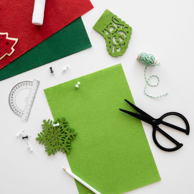 Vue de dessus des éléments essentiels pour créer un cadeau de Noël avec des ciseaux et du papier