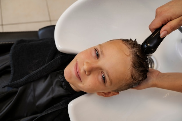 Photo gratuite vue de dessus enfant se laver les cheveux au salon