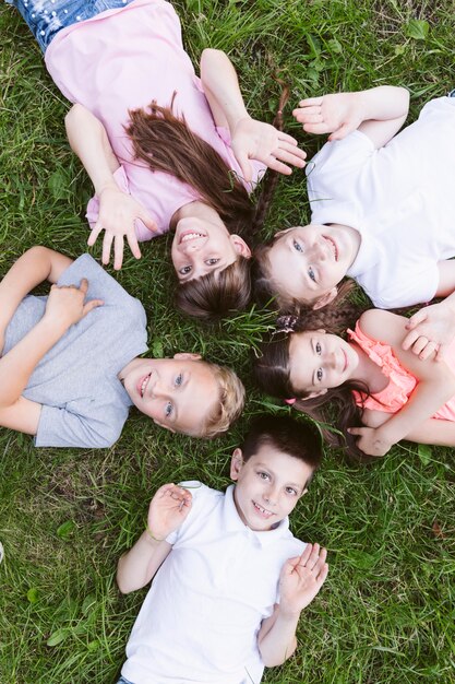 Vue de dessus des enfants heureux, souriant à la caméra