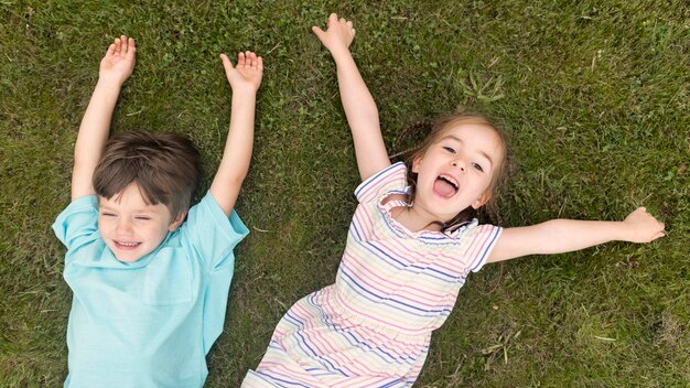 Vue de dessus des enfants posés sur l'herbe