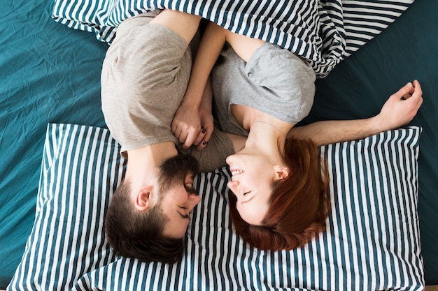 Vue de dessus à l'envers couple assis dans son lit