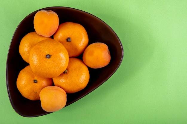 Photo gratuite vue de dessus espace copie mandarines dans un bol sur vert clair