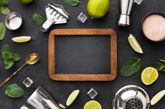 Vue de dessus des essentiels de cocktail avec tableau noir et citron vert