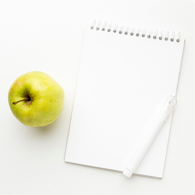 Vue de dessus des essentiels de la rentrée avec pomme et ordinateur portable