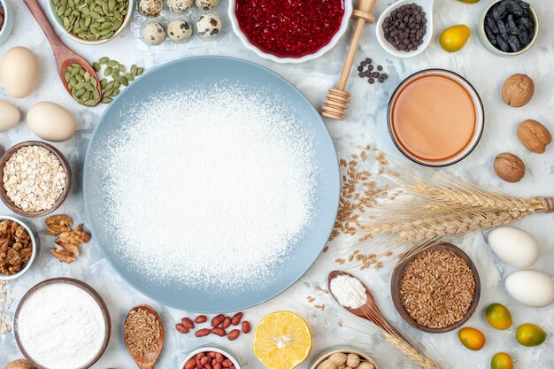 Vue de dessus de la farine blanche à l'intérieur de l'assiette avec des graines de noix et des œufs sur de la pâte blanche gelée de noix photo couleur alimentaire