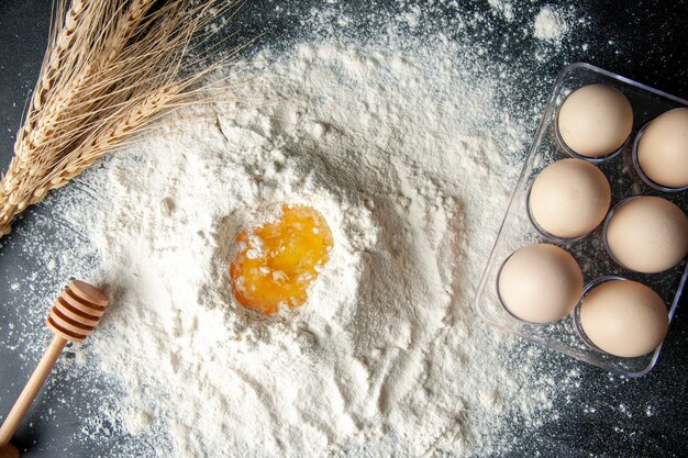 Vue de dessus de la farine blanche mélangée avec des œufs sur le fond sombre travail de pâtisserie gâteau aux œufs tarte boulangerie travailleur cuisine