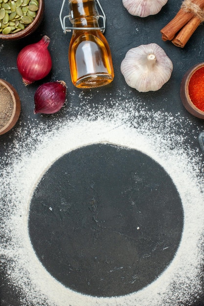 Photo gratuite vue de dessus farine de forme ronde avec des œufs de légumes et des assaisonnements sur fond sombre gâteau de couleur biscuit au thé blanc biscuit