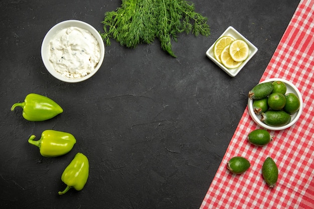 Vue de dessus feijoa et citron avec poivrons verts et légumes verts sur la surface sombre repas de légumes fruits