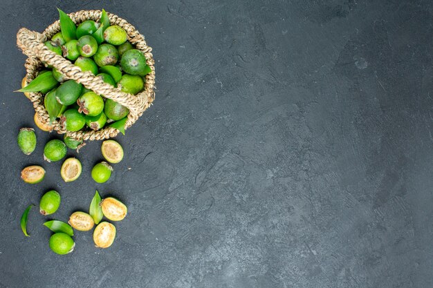 Vue de dessus feijoas frais dans le panier sur une surface sombre avec espace de copie