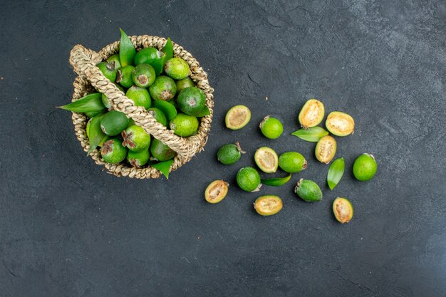 Vue de dessus feijoas frais dans le panier sur une surface sombre