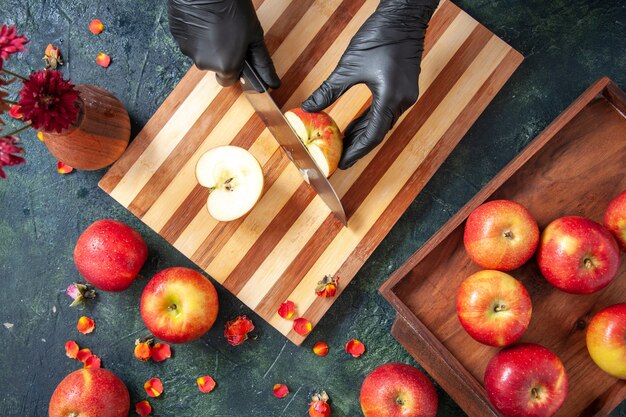 Vue de dessus femme cuisinier coupant des pommes sur la surface grise