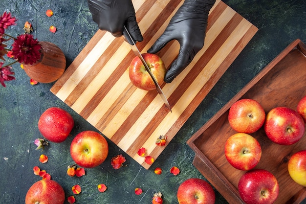 Vue de dessus femme cuisinier coupant des pommes sur la surface grise