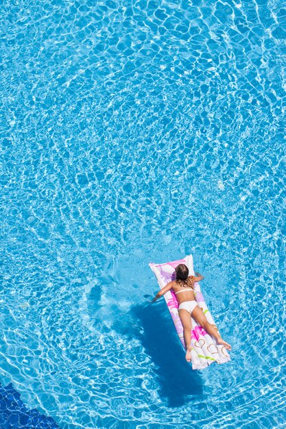 Vue de dessus de la femme dans la piscine avec airbed