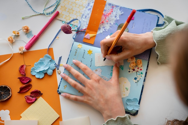 Photo gratuite vue de dessus femme faisant un journal créatif