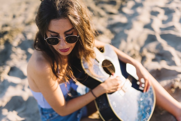 Photo gratuite vue de dessus de la femme avec la guitare sur le sable