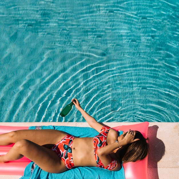 Vue de dessus de la femme se détendre à côté de la piscine