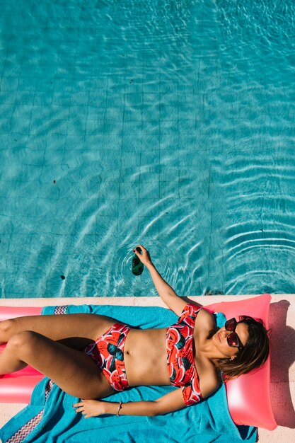 Vue de dessus de la femme se détendre à côté de la piscine