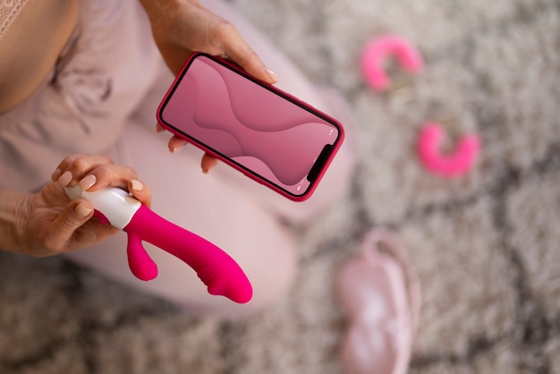 Vue de dessus femme avec smartphone et vibrateur